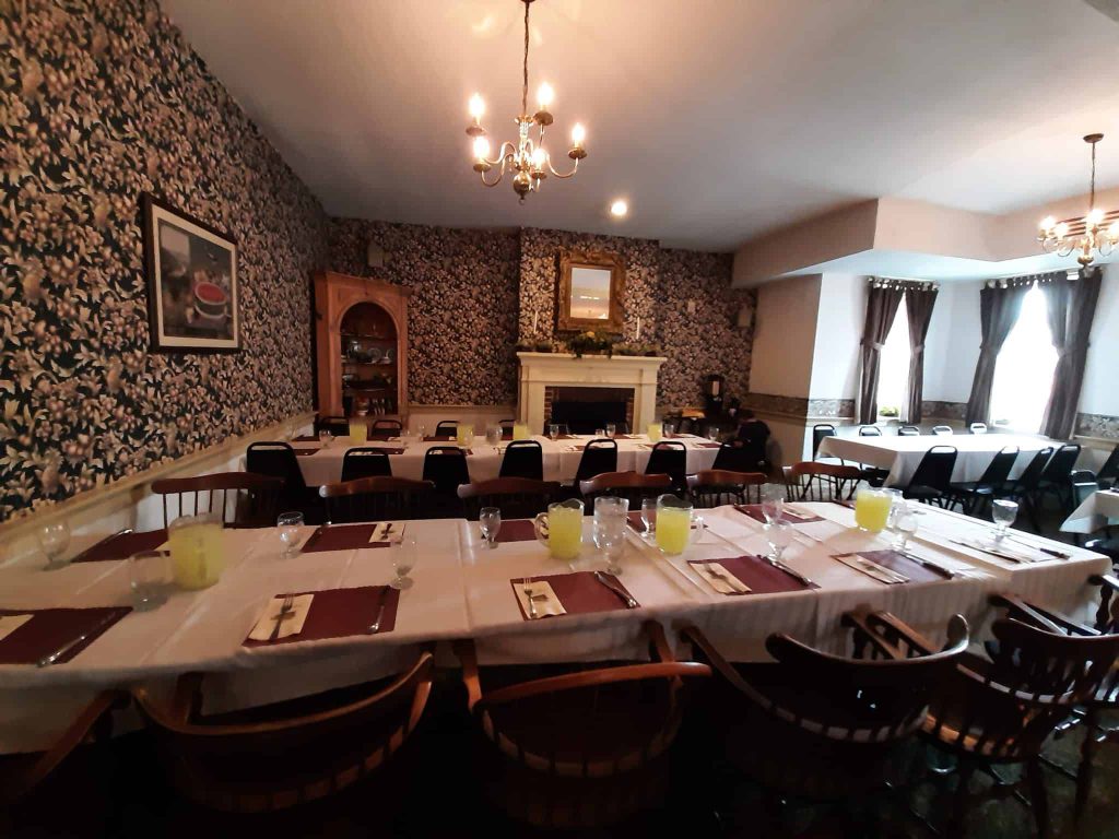 Abigail Adams Ballroom set with long dining tables and white linens.