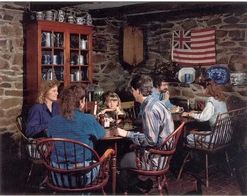 Guests at a table beside the stone fireplace in the Springhouse Tavern.